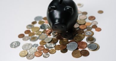 Piggy bank with a stack of coins falling into it symbolizing savings and financial planning."
