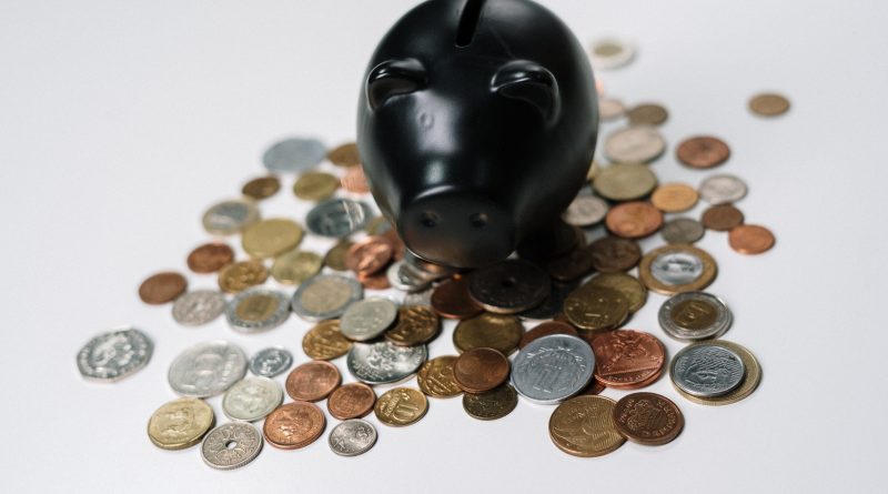 Piggy bank with a stack of coins falling into it symbolizing savings and financial planning."